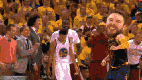 a basketball player in a golden state warriors uniform is dancing in front of a crowd