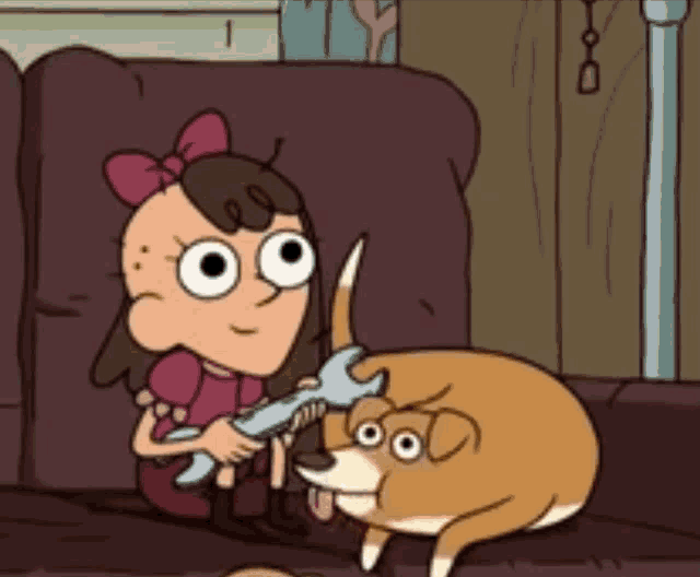 a girl is holding a wrench next to a brown dog
