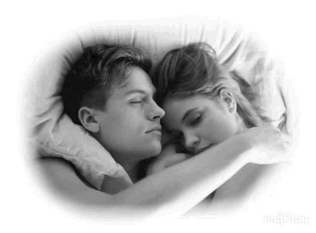 a black and white photo of a man and woman sleeping together