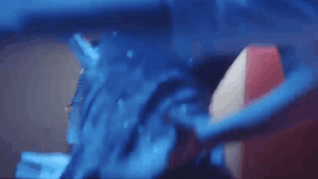 a close up of a blue liquid being poured into a container .