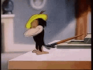 a cartoon character is standing on a table with a hammer .