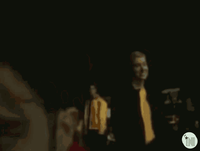a blurry picture of a man in a red jacket with the letter n in the corner