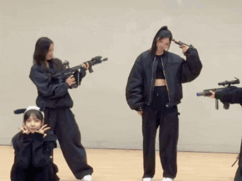 a group of women are holding guns in a room