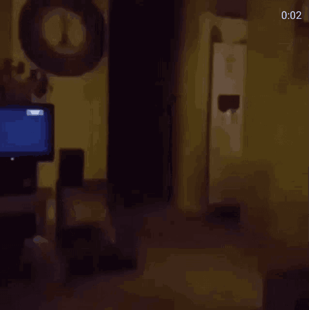 a dark room with a television and a clock on the wall .