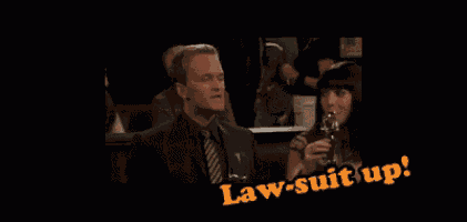 a man in a suit and tie is sitting next to a woman holding a glass of wine and the words law suit up are visible