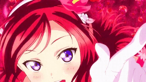a close up of a girl with red hair and blue eyes giving a thumbs up sign .