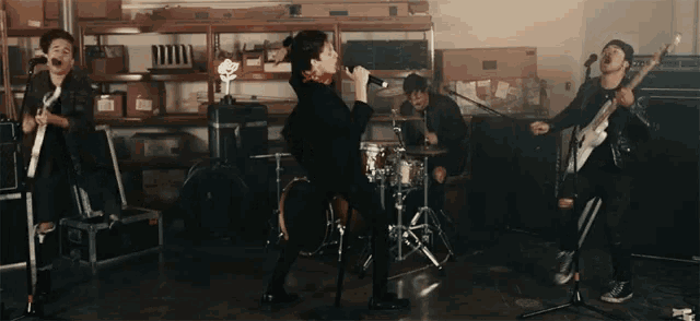 a man singing into a microphone while playing drums