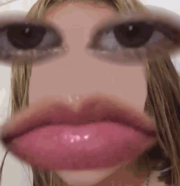 a close up of a woman 's face with glasses on and a big mouth .