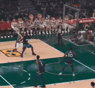 a basketball game is being played on a court sponsored by state farm .