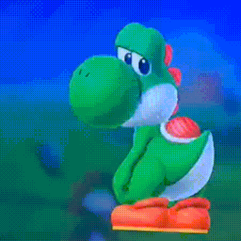 a green dinosaur is sitting on top of a red and orange item .