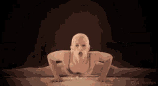 a woman in a bikini is doing a split in a dark room .