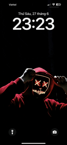 a phone screen shows a person wearing a mask and the time is 23:23
