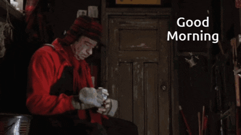 a man in a red jacket is sitting in front of a door with the words " good morning " written on the bottom