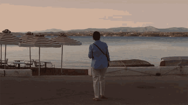 a man stands in front of a body of water