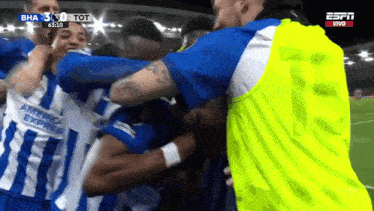 a group of soccer players are hugging each other and one of them is wearing an american express jersey