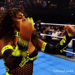 a woman in a wrestling ring with the word caution on her arms