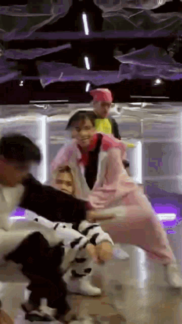 a group of young people are dancing together in a room .