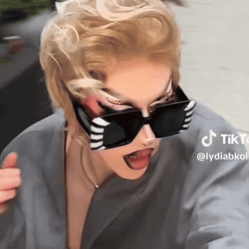 a woman wearing sunglasses is giving a thumbs up with a tiktok watermark