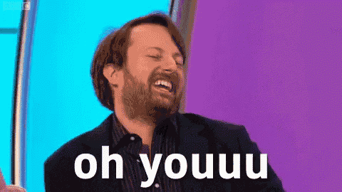 a man with a beard is laughing in front of a purple background .