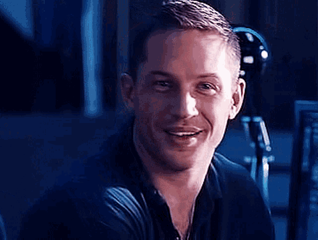 a close up of a man in a black shirt smiling .