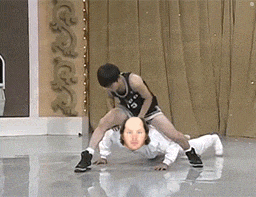 a man in a black tank top with the number 15 on it is pushing another man