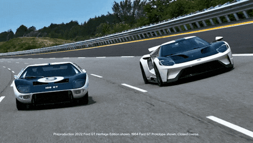 two ford gt cars are driving down a highway