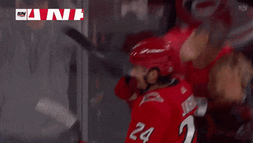a hockey player with the number 20 on his jersey is hugging another player