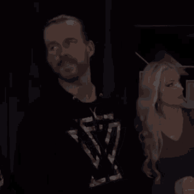 a man and a woman are standing next to each other .