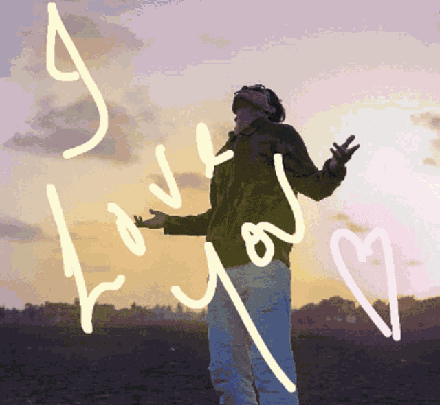 a man stands in front of a sunset with the words " love you " written on it