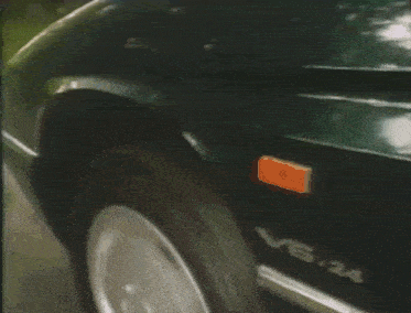 a car is driving down a road with trees in the background and a license plate that says ' aa ' on it