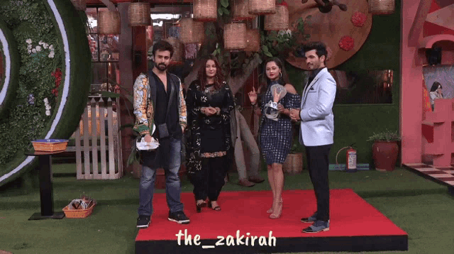a group of people standing on a red carpet with the hashtag the_zakirah on it