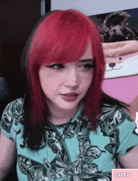 a woman with red hair and freckles is wearing a blue shirt with a butterfly print