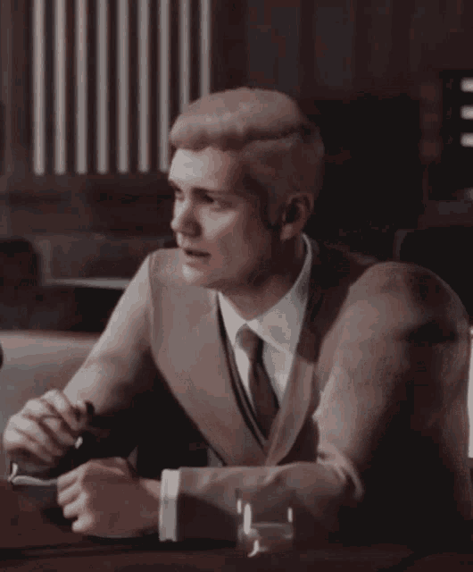 a man in a suit and tie is smoking a cigarette