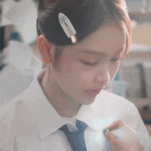 a girl with a hair clip in her hair is looking down