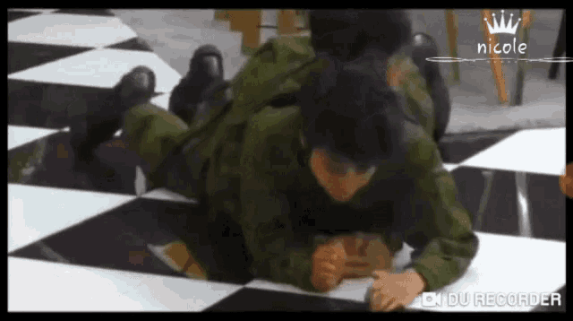 a man in a military uniform is laying on the floor with a nicole logo in the corner .