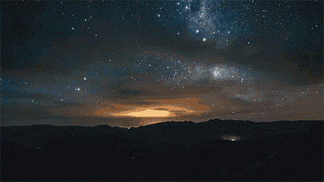 a night sky with a lot of stars and mountains in the background