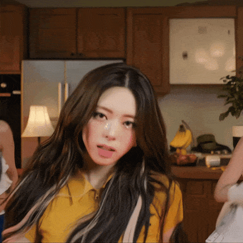 a woman in a yellow shirt sticks out her tongue