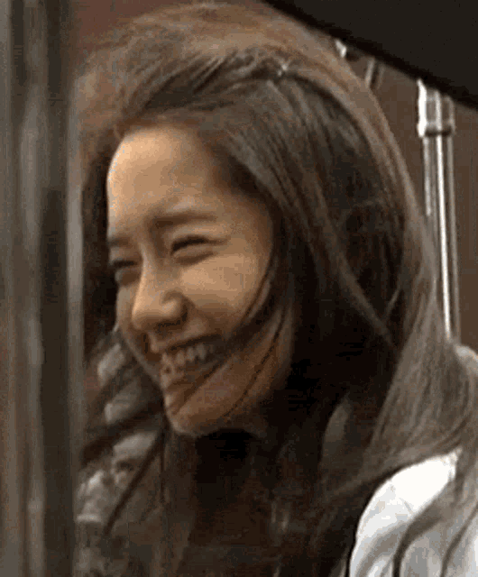 a woman with long hair is smiling with her mouth open .