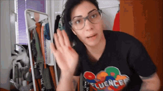 a woman wearing glasses and a t-shirt that says fluencer