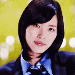 a woman wearing a suit and tie is smiling