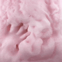 a person 's hand is touching a pile of pink foam .