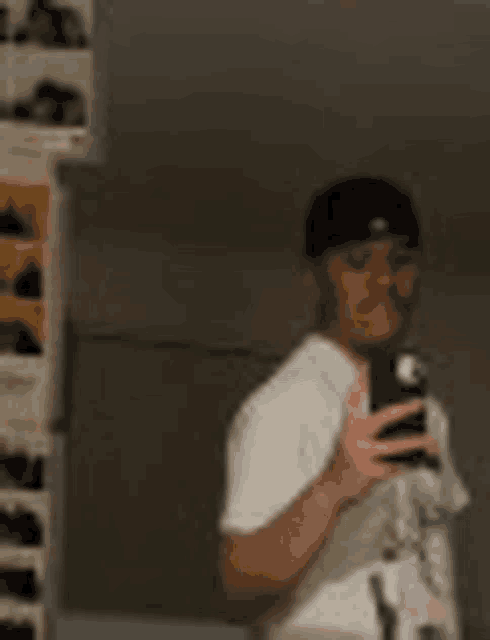 a man is taking a picture of himself in a mirror with a cell phone .