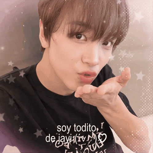 a young man blowing a kiss with a shirt that says soy todito on it