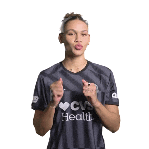 a woman is wearing a cvs health shirt and giving a thumbs up