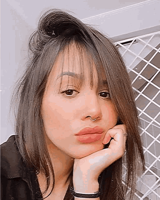 a close up of a woman 's face with her hand on her face