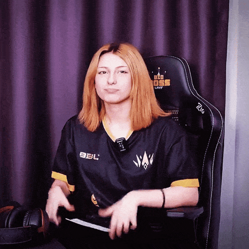 a woman sitting in a chair with a shirt that says bbl on it