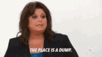 a woman says the place is a dump while wearing a blue dress