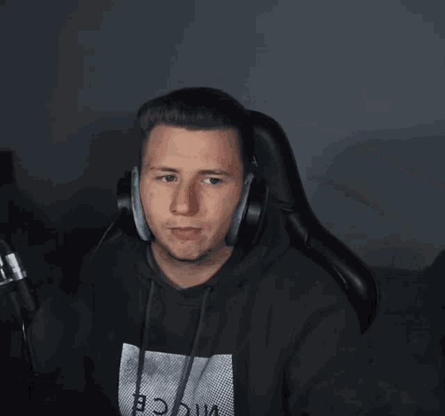 a man wearing headphones and a shirt that says a on it salutes