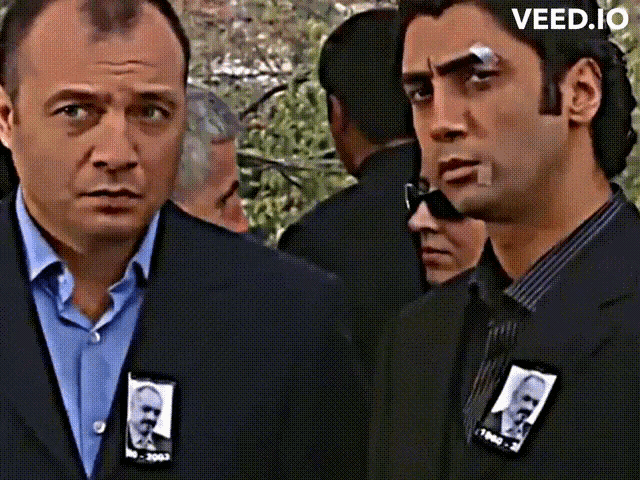 two men are standing next to each other and one has a patch with a picture of a man and the year 1963 on it