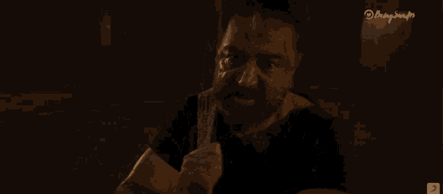 a man with a beard is holding a rope in a dark room with the word el corte ingles on the bottom right